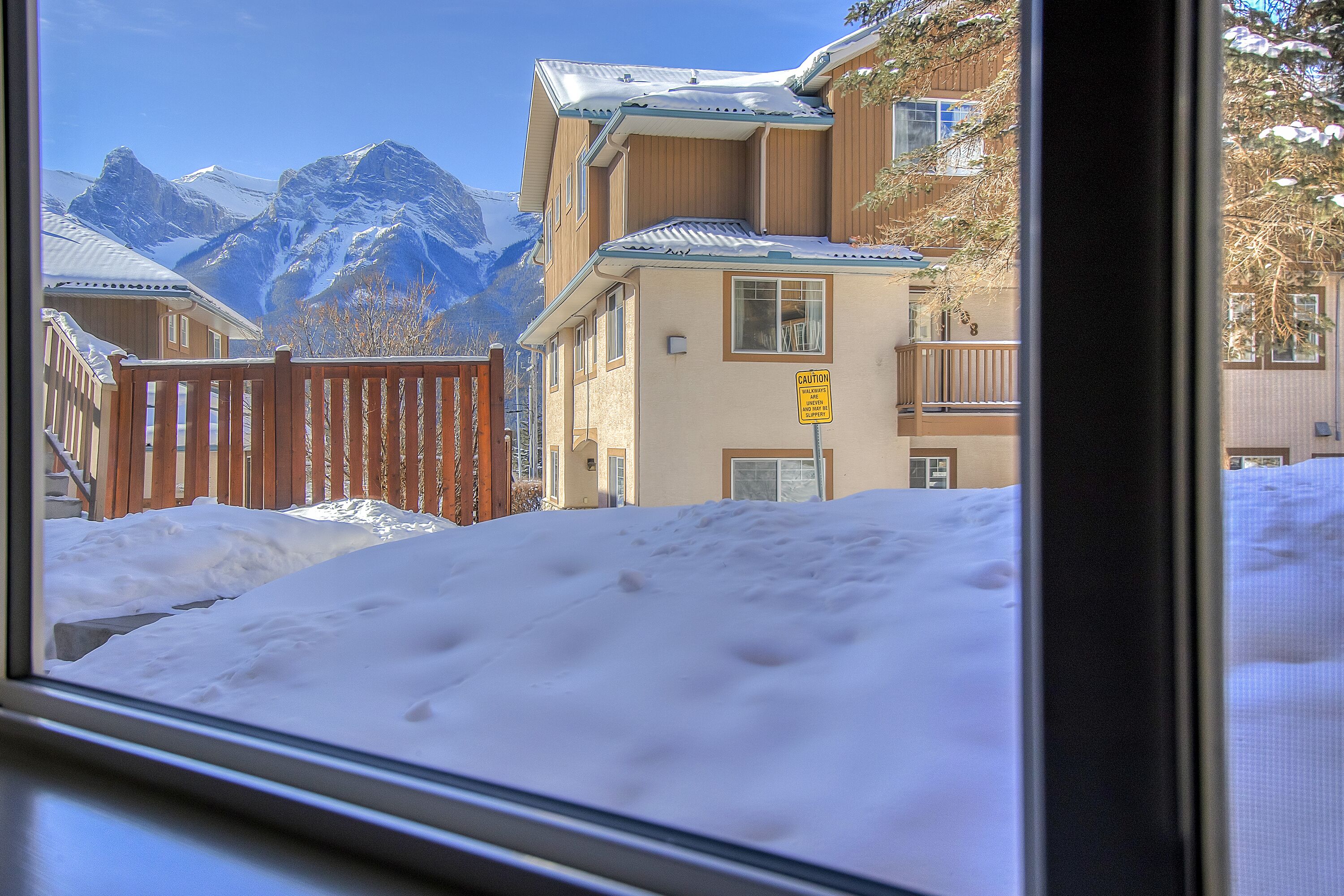 A view of a snowy mountain landscape with buildings in the foreground.