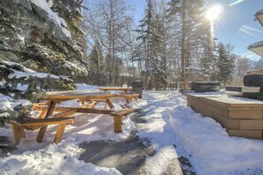 A snow-covered outdoor area with picnic tables and a barbecue grill. - Spacious condo unit Getaway to the Rocky (Canmore)