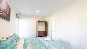 Una habitación de hotel con una cama, un armario y una puerta.