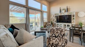 A spacious living room with a large TV, comfortable seating, and a view through the glass doors. - Sleeps 12~Great View! UNR~Deck~Reno~Minerva House~ Near Downtown~Family Fun (Reno)