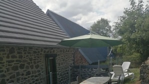 Un bâtiment en pierre doté d’un patio couvert.