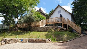 A house with a wooden deck and a stone wall.