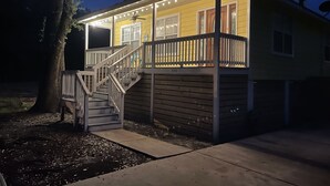 Une maison avec un porche couvert, un escalier et le numéro « 220 » peint sur le mur.