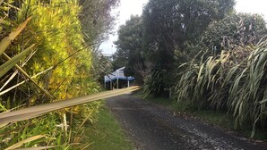 A wooden post with the number 490, a gravel path, and a blue-roofed structure in the background.