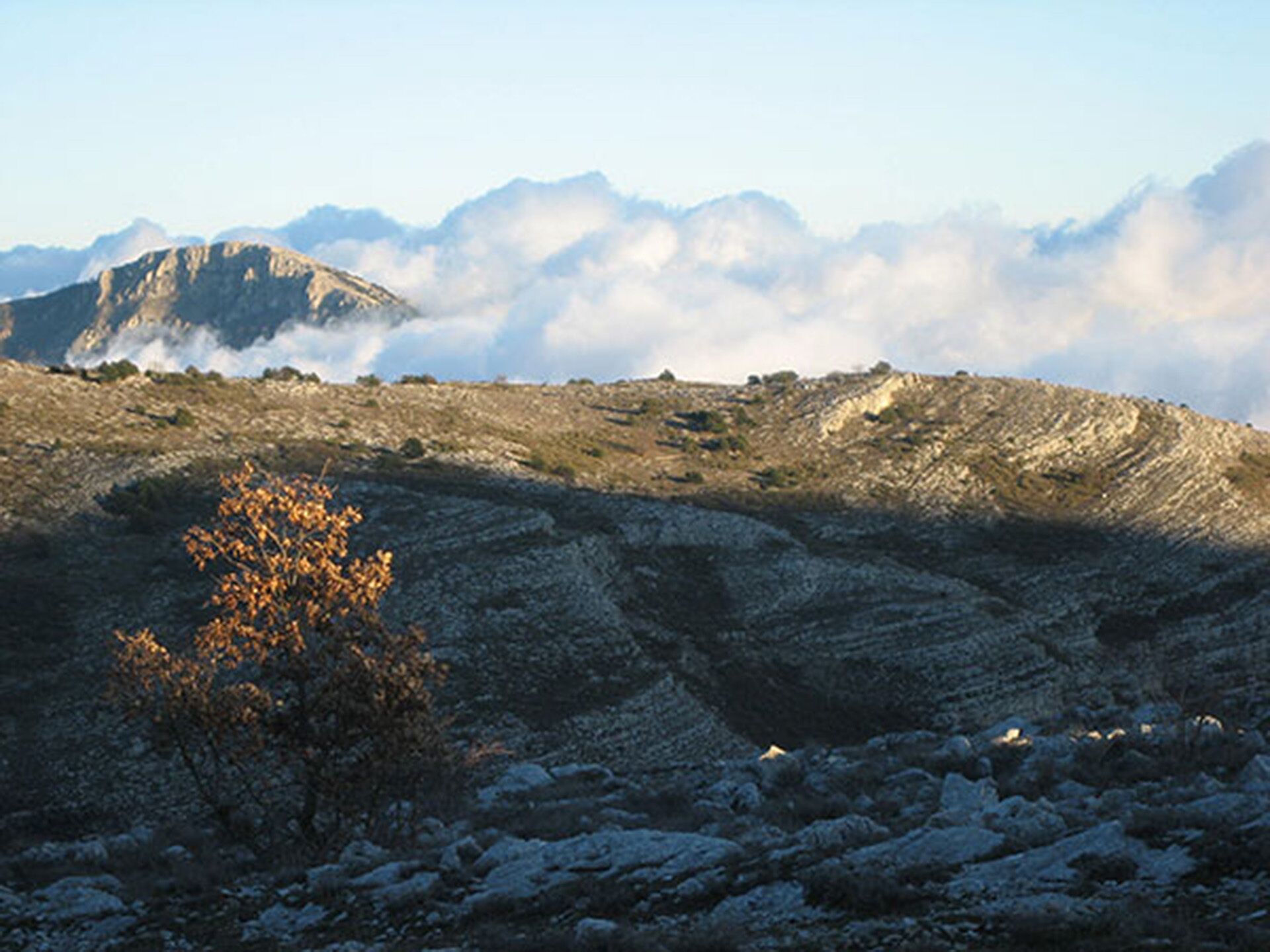 A mountainous landscape with rocky terrain and sparse vegetation.