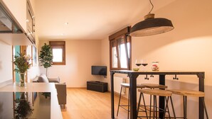 Una cocina moderna con comedor, piso de madera y un amplio ventanal que proporciona luz natural.