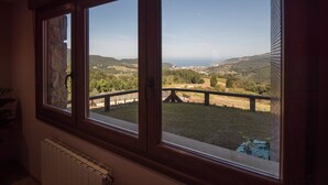 Una habitación con vista a un paisaje con pastizales y colinas.