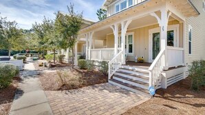 A two-story house with a covered porch and a brick pathway leading to the front door. - Beargrass -Luxury NatureWalk Home - Golf Cart (Santa Rosa Beach)