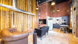Ein stilvoller Lounge-Bereich mit einer Ledersofa, schwarzen Sesseln und einer Bambuswand.