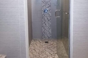 Een aparte badkuip en douche, een diep bad, handdoeken