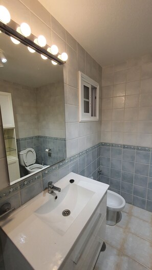 Een douche, een haardroger, een bidet, handdoeken