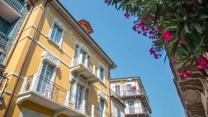 A yellow building with ornate balconies and a clear blue sky. - Beautiful Apartment in Piemonte - Wifi Free (Verbania)