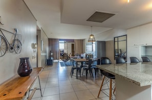 Una cocina moderna con comedor, una isla grande y una decoración de bicicleta en la pared.