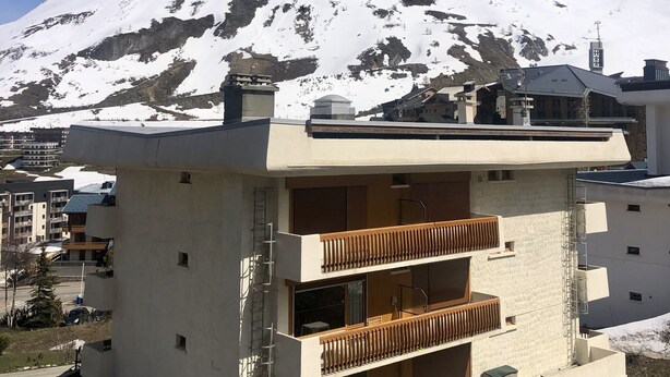 A modern building with a balcony, set against a snowy mountain backdrop. - Studio Dans une Petite Copropriété en Plein Centre de Tignes (Tignes)