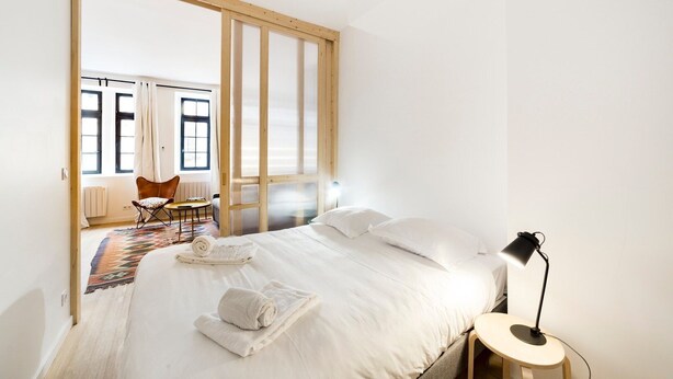 Una habitación de hotel con cama, escritorio, silla y vistas al exterior.