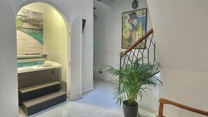 Um interior moderno com escada, banheira de hidromassagem e um quadro.