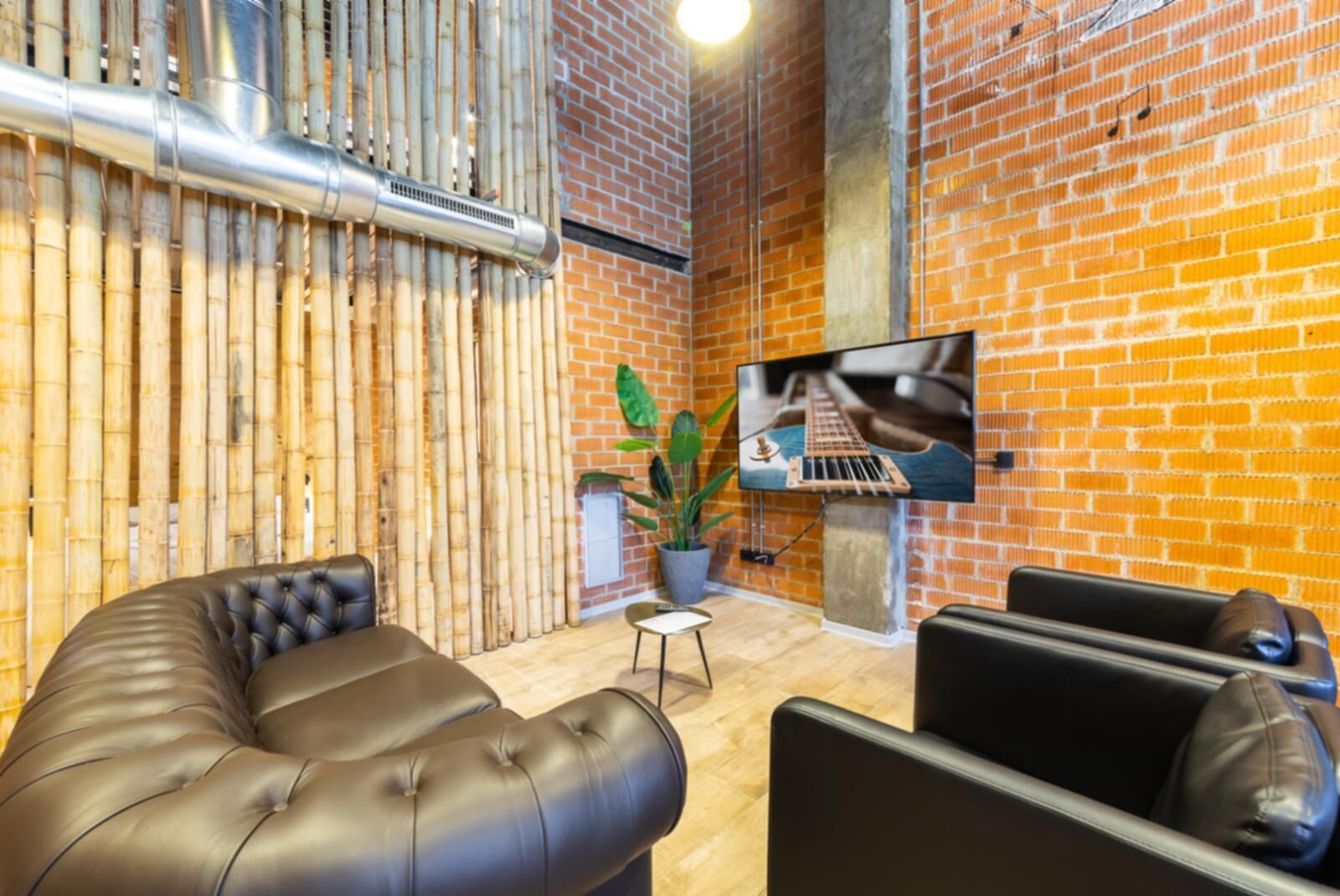 Un salon moderne avec un mur en briques, un téléviseur à écran plat et un barbecue intégré.