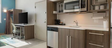 A modern kitchen with built-in appliances, a dishwasher, and a countertop with a coffee maker.