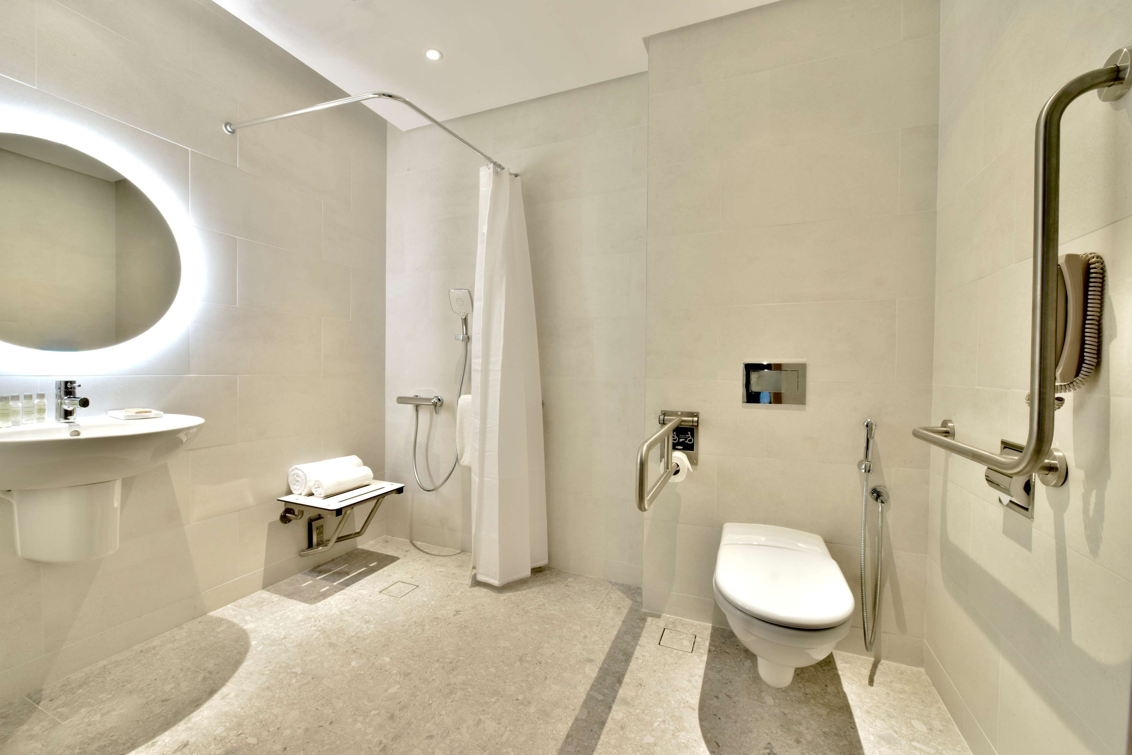 A modern bathroom with a shower, toilet, and sink.