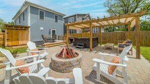 A backyard with a fire pit, outdoor seating, and a pergola. - Blue Haven Home, Fire Pit & Blocks from Beach (Cape Charles)