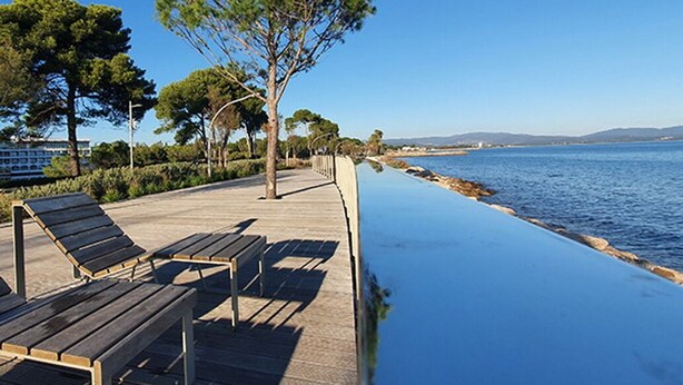 A coastal walkway with benches and a clear view of the sea. - Superb contemporary villa PIED DANS L'EAU - plage de l'Ayguade / with plancha (Hyères)