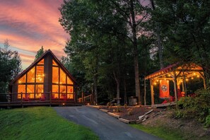 A cabin with large windows, a deck, and a covered outdoor seating area. - … Quiet Cabin Getaway … Close to Town … Hot Tub … (Sevierville)