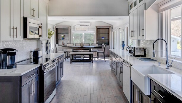 A modern kitchen with a central island, stainless steel appliances, and ample natural light from large windows.