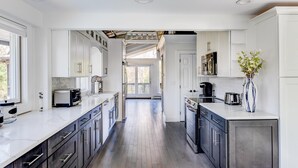 A modern kitchen with white cabinetry, a central island, and a view to a balcony.