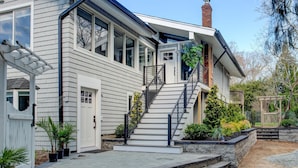 A two-story house with a front porch, a staircase, and a brick chimney.