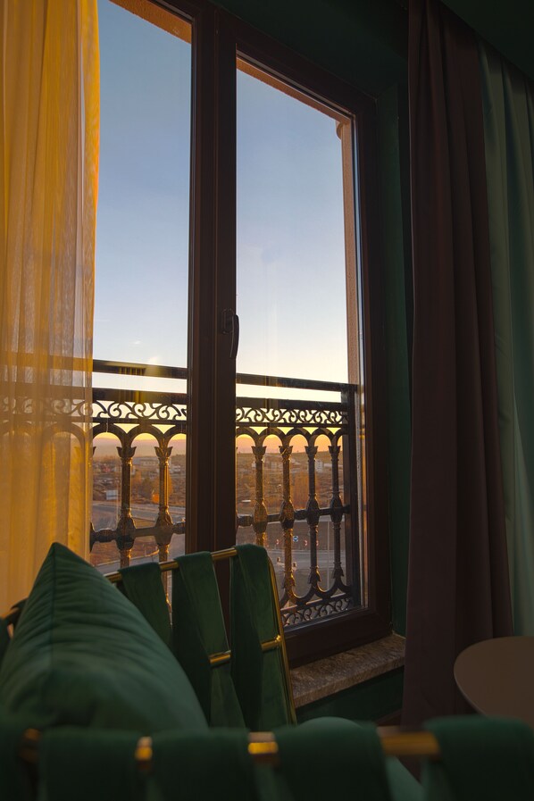 A room with a view of a cityscape through a window with a decorative iron railing. - Elifim Resort Hotel (Gerede)