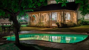 A traditional-style building with a pool, surrounded by greenery and a well-maintained lawn. - Seagrapes Villa (Discovery Bay)