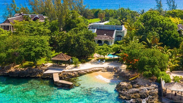 A coastal property with a private beach, a gazebo, and a pool area surrounded by lush greenery. - Seagrapes Villa (Discovery Bay)
