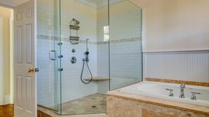 A modern bathroom with a glass-enclosed shower, a marble sink, and a white tiled shower area. - Traditional East Hampton Estate (East Hampton)