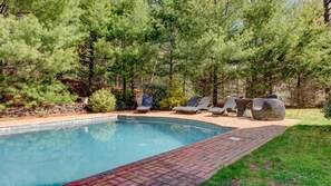 A swimming pool with lounge chairs and a stone wall. - Traditional East Hampton Estate (East Hampton)