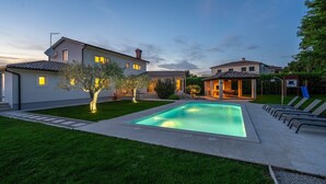 A residential property with a swimming pool, a covered patio, and a well-maintained lawn. - Lovely Villa Gemini with a swimming pool (Visnjan)