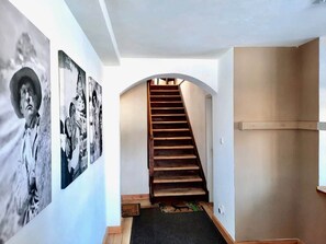 A staircase leading to an upper floor, flanked by walls with black and white photographs. - Kitz Apartment 2 mit Garten Nähe Schwarzsee (Kitzbühel)