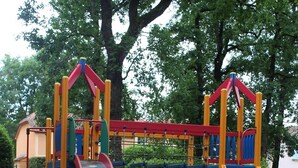 Une aire de jeux avec un toboggan, des structures d’escalade et un petit pont.