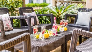 Wicker furniture with floral cushions, a table with glasses of Sangria, lemons, and flowers. - House Sa Dalia very close to Alcudia Beach (Alcúdia)