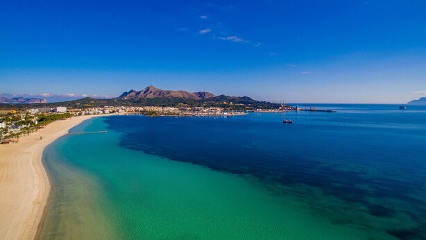 A coastal town with a beach, clear blue waters, and a mountain in the background. - House Sa Dalia very close to Alcudia Beach (Alcúdia)