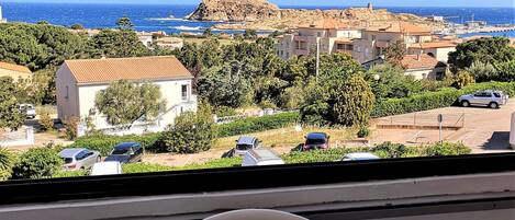 A table with breakfast items and a view of a coastal town.