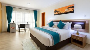 A neatly arranged bedroom with a bed, bedside table, and a desk. - Casa Misa Westlands (Nairobi)