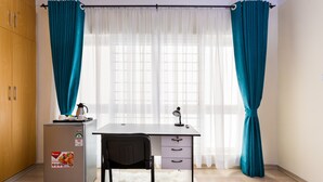 A compact room with a desk, chair, and a small refrigerator. - Casa Misa Westlands (Nairobi)