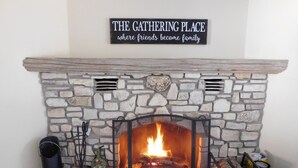 Ein Kamin aus Stein, über dem ein Schild mit der Aufschrift 'The Gathering Place where friends become family' steht.