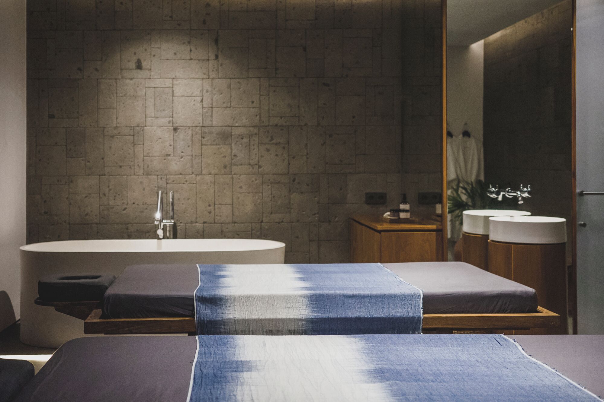 Une salle de bain moderne dotée d’une grande baignoire, de deux lavabos et d’un meuble-lavabo en bois.