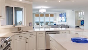 Una cocina moderna con armarios blancos, lavavajillas y estufa.