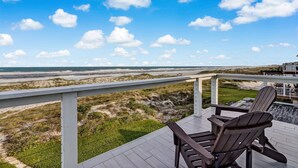 A deck with two Adirondack chairs overlooking a beach and dunes. - Pet friendly, newly renovated, ocean and beachfront historical home (Fernandina Beach)