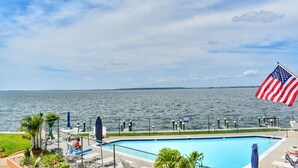 Una piscina con vista al océano y un muelle a lo lejos.