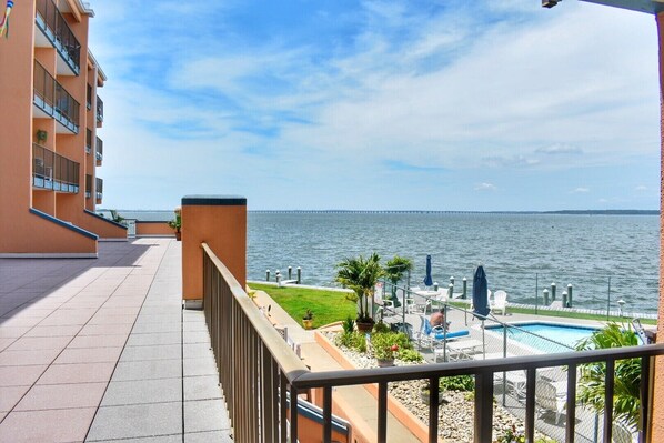 Ein Balkon mit Blick auf das Wasser und eine entfernte Brücke.