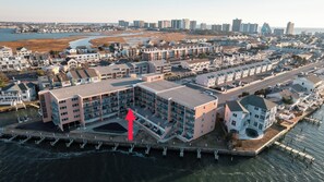 Ein Luftbild eines Küstenwohngebiets mit modernen Mehrfamilienhäusern, einem Yachthafen und einer Uferpromenade.