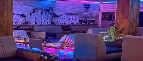 A modern lounge area with sofas, a coffee table, and a mural of buildings.